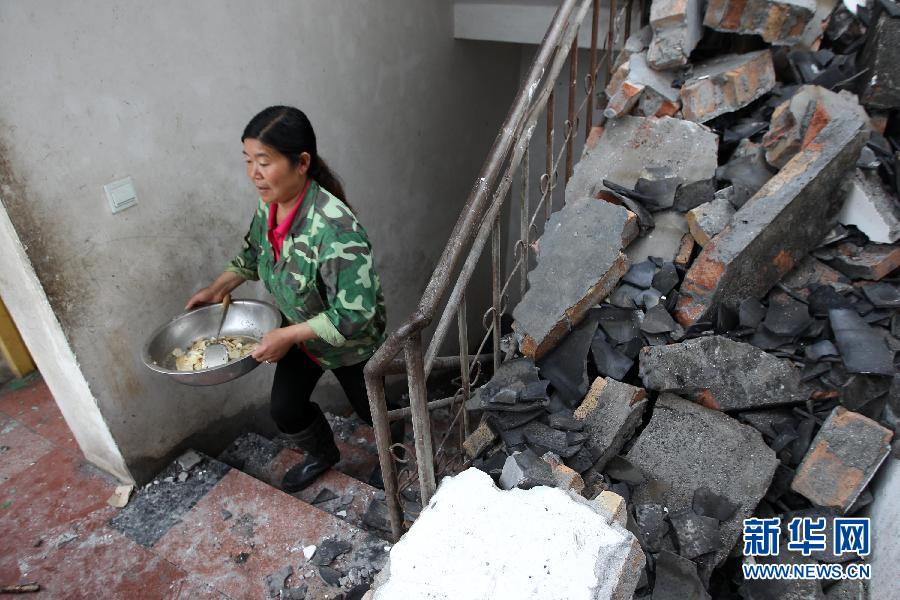 4月23日，岳艳母亲在家中准备做饭。家中的二层小楼垮塌严重。.jpg